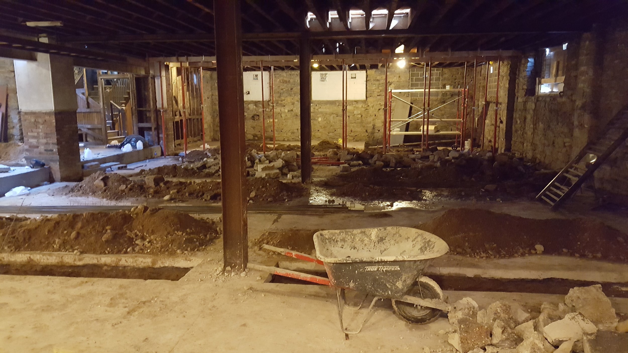 New concrete walls divide the basements of the five houses. Here, you can see the trenches for the new footings, as well as the existing steel columns and beams.