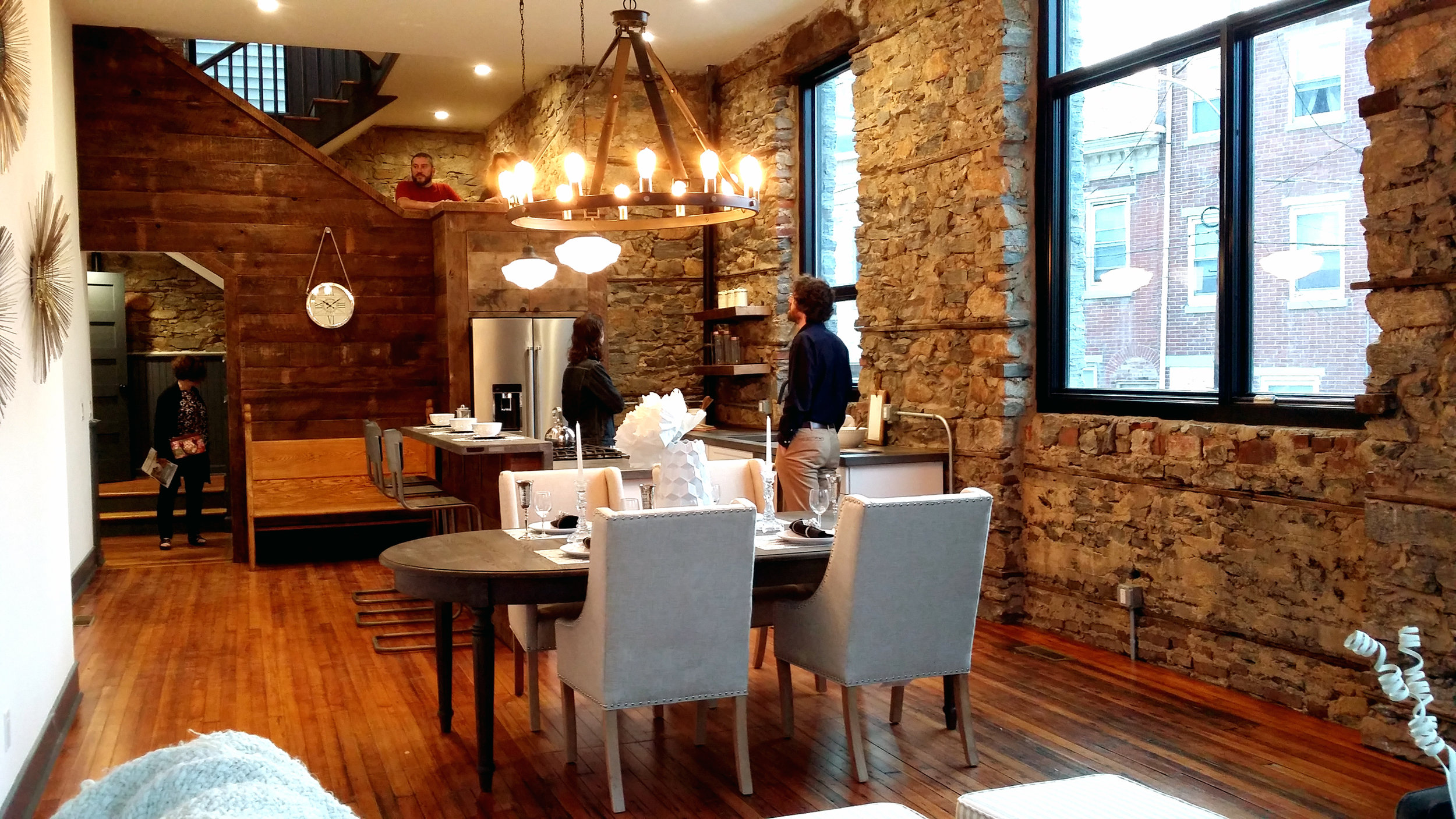 This is the main floor, with kitchen, dining, and living space. The original stone walls are exposed, and the wood floors are original. The wood paneling is salvaged from the original structure.