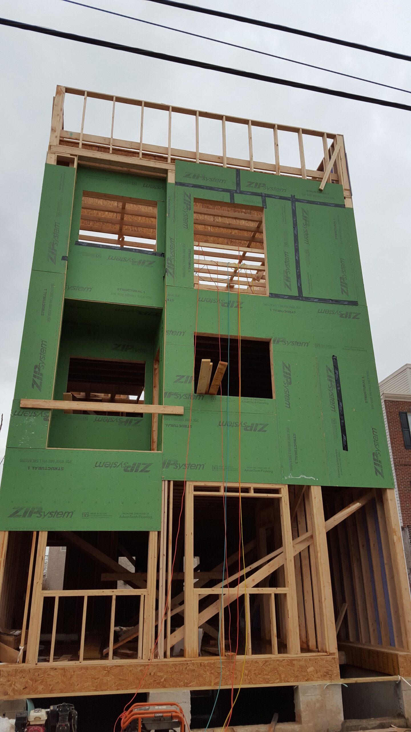 sheathing going up on the exterior; framing has been topped out